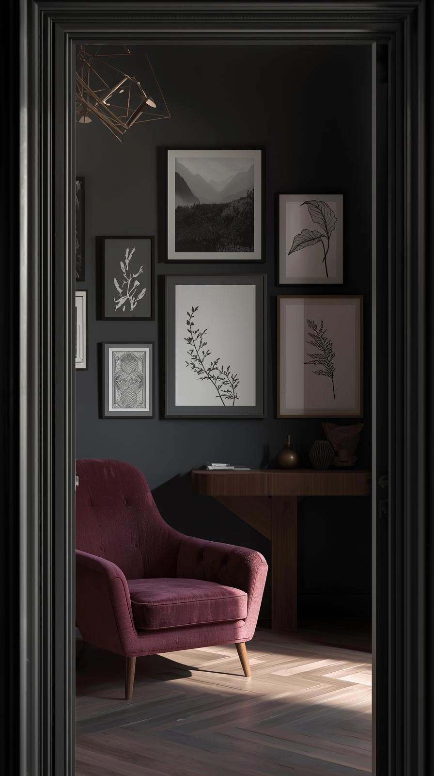 Dark feminine aesthetic room with moody art and black-and-white photography in matte black and brass frames on a deep-colored wall.